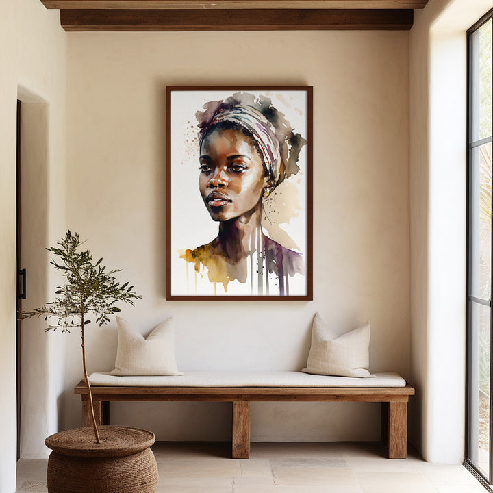 A large framed 'Aisha Rising' fine art print hanging in a sophisticated, neutral-toned entryway. The watercolor portrait brings color, depth, and modern elegance to the minimalist interior.
