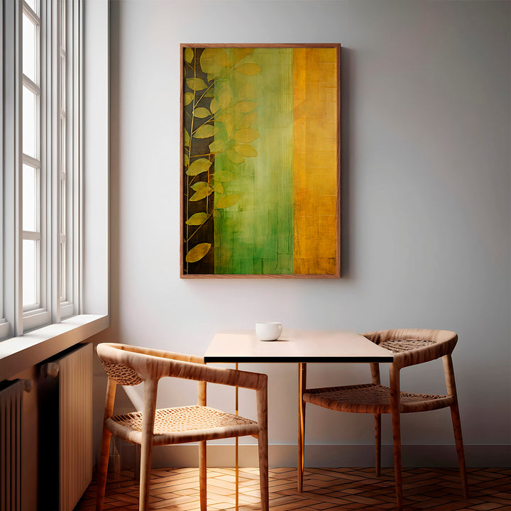 Framed 'Botanical Dawn' wall art displayed above a small dining table, featuring earthy green and ochre tones with a leaf silhouette. An ideal print for contemporary natural interiors.