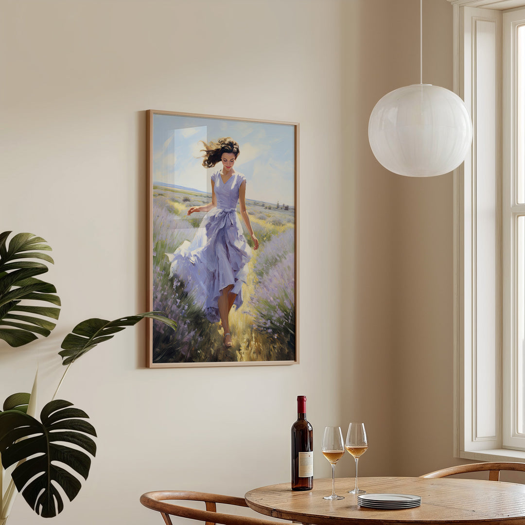 Framed artwork of a woman in a lavender field on a wall above a table with wine and glasses.