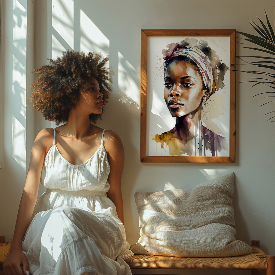 A framed 'Aisha Rising' portrait on a sunlit wall, with a woman sitting nearby, immersed in the artwork. The powerful watercolor portrait infuses the serene space with warmth and femininity.